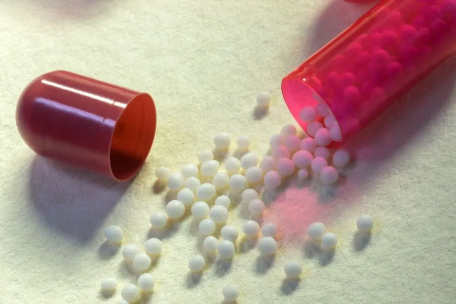 Microencapsulated ingredients in a capsule spilling out onto a table.